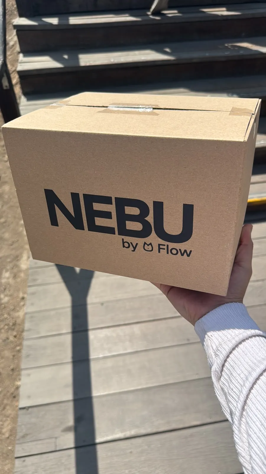 Una persona sostiene la caja de Nebu antes de entregarla
