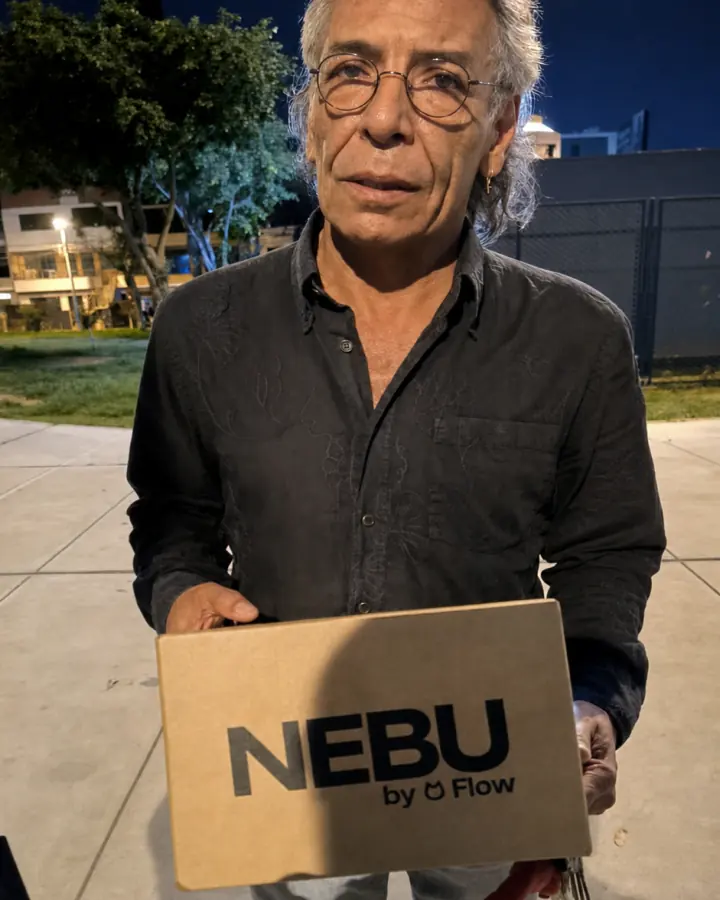 Cliente sosteniendo una caja de Nebu durante una entrega nocturna