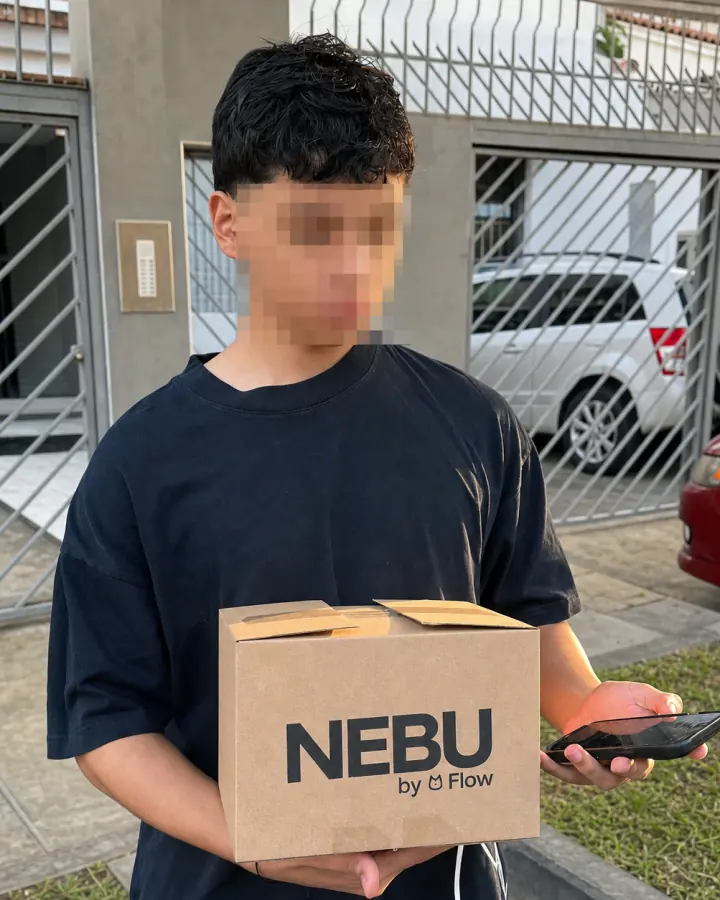 Joven con el rostro pixelado sosteniendo una caja de Nebu durante una entrega