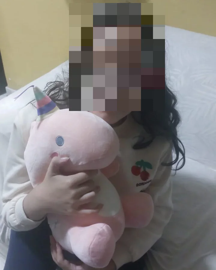 Joven con el rostro pixelado sosteniendo su compañero Nebu Unicornio en casa