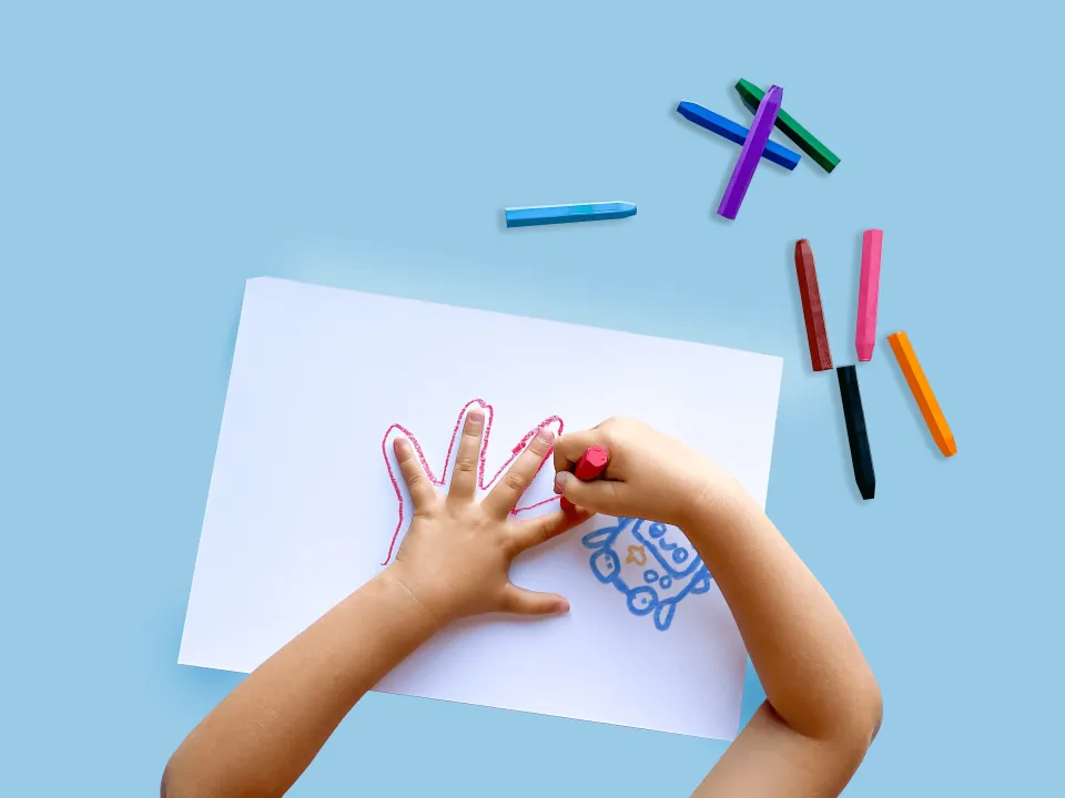 Niño dibujando y creando con crayones de colores