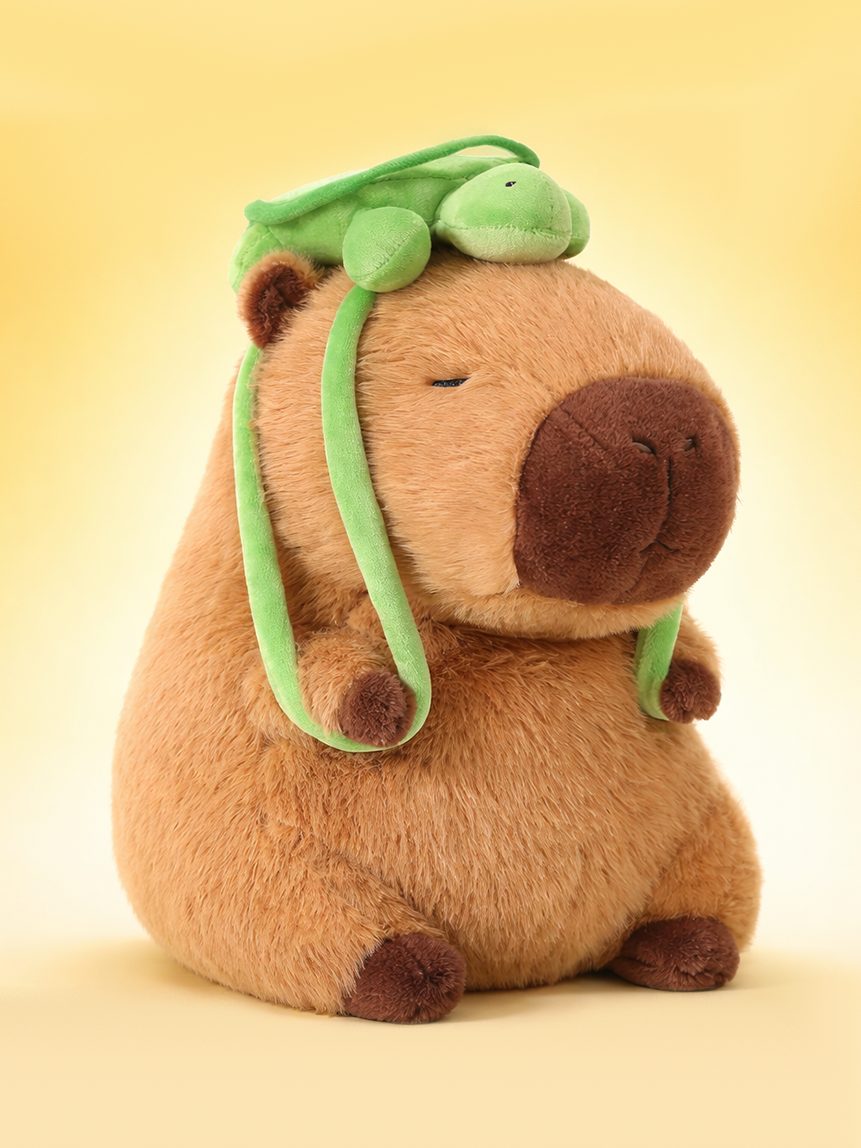 Peluche Nebu capibara con una tortuga verde sobre la cabeza.